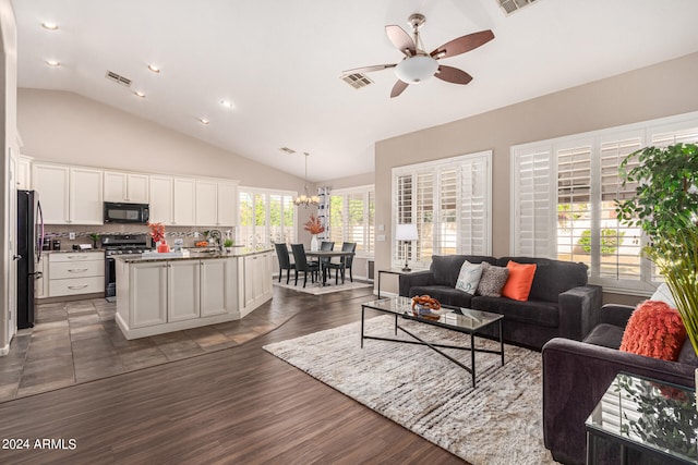 living room with lofted ceiling, dark hardwood / wood-style flooring, and ceiling fan with notable chandelier