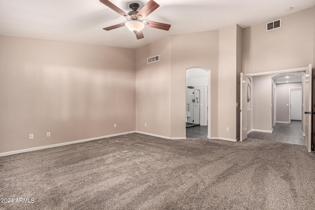 spare room featuring ceiling fan and dark colored carpet