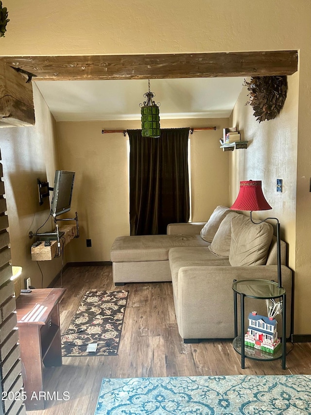 living room with beamed ceiling, baseboards, and wood finished floors