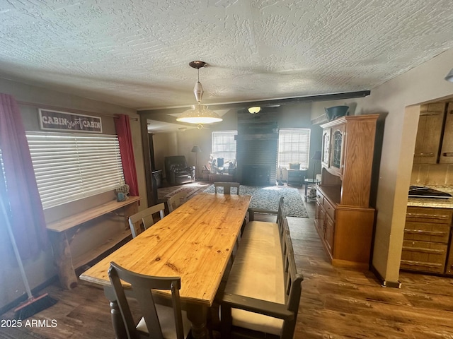 dining area featuring dark wood-style flooring and a textured ceiling