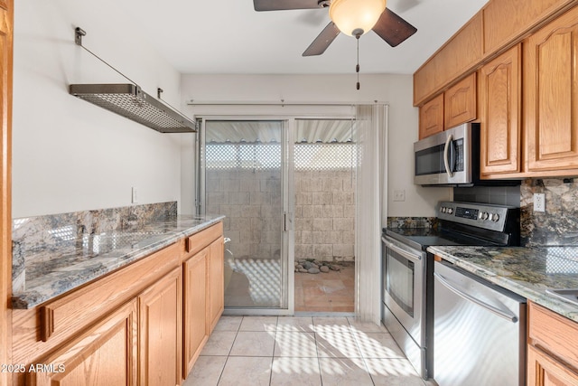 kitchen with stone counters, light tile patterned floors, appliances with stainless steel finishes, and tasteful backsplash