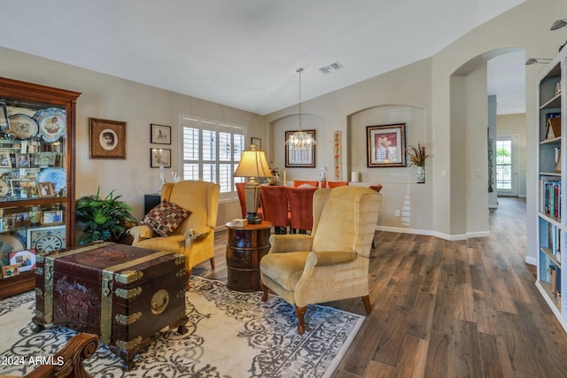 living area with a chandelier and dark wood-type flooring