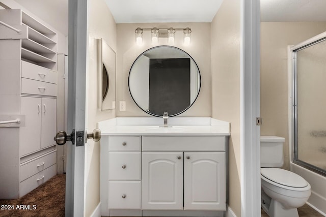 full bathroom with vanity, bath / shower combo with glass door, and toilet