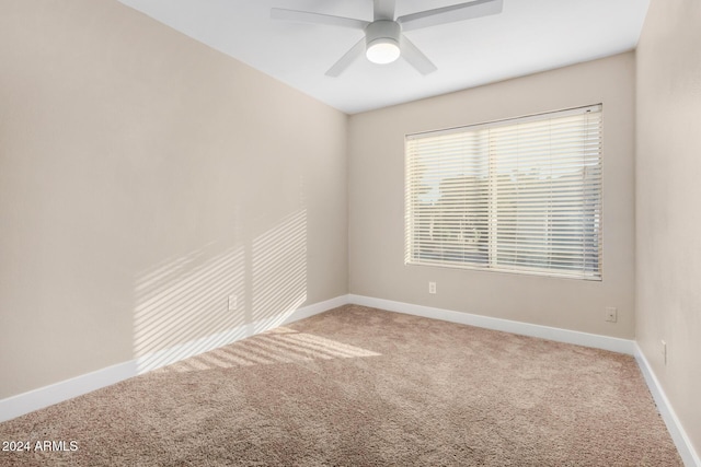 spare room with ceiling fan and carpet