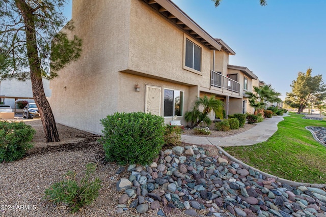 rear view of property with a lawn and a balcony