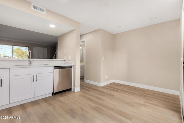 kitchen with crown molding, sink, stainless steel dishwasher, light wood-type flooring, and white cabinetry