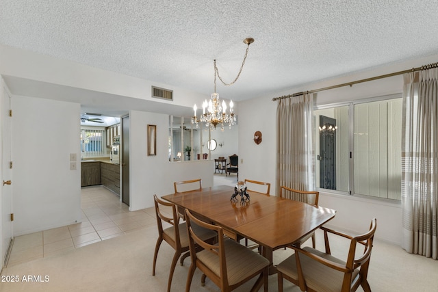 dining space with ceiling fan with notable chandelier, light colored carpet, and a textured ceiling