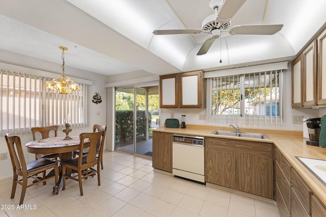 kitchen with dishwasher, sink, light tile patterned flooring, and decorative light fixtures