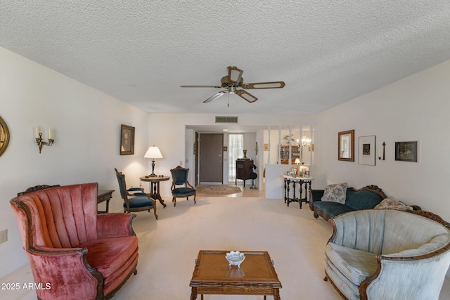 living room with ceiling fan with notable chandelier, a textured ceiling, and carpet