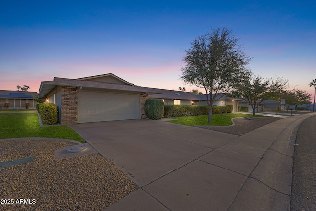 single story home featuring a garage and a yard