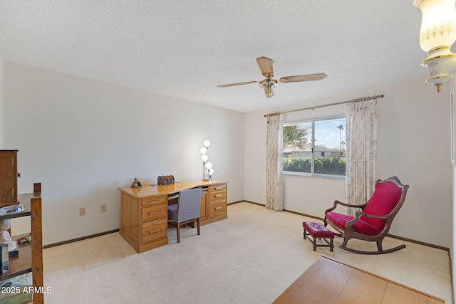 carpeted office space with a textured ceiling and ceiling fan