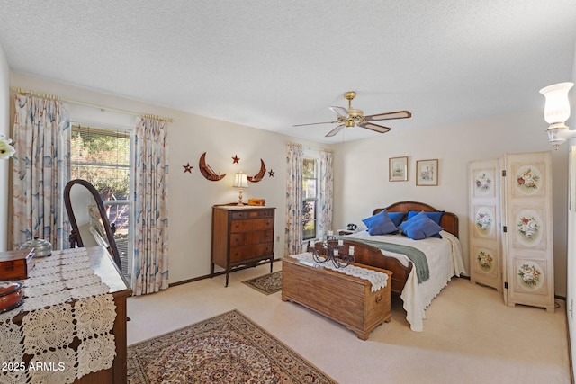 bedroom featuring ceiling fan, light colored carpet, and a textured ceiling