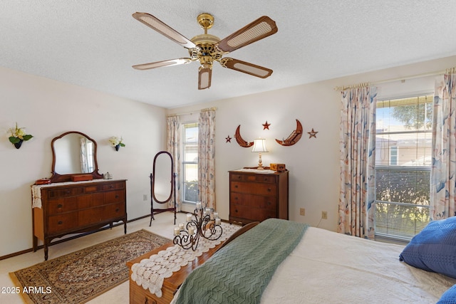 carpeted bedroom with ceiling fan and a textured ceiling