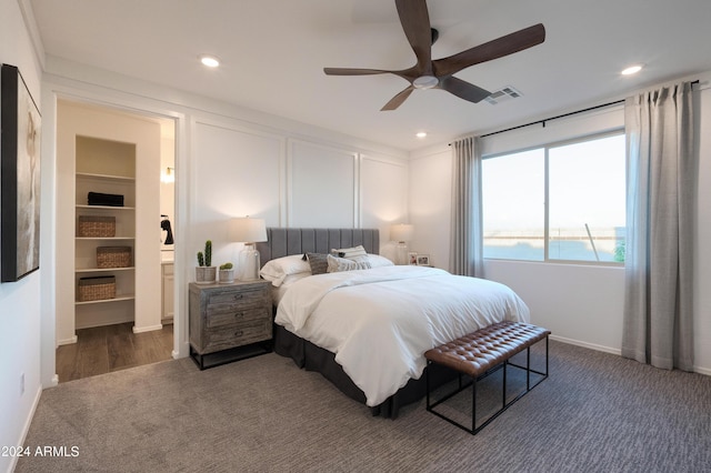 bedroom with ceiling fan, a water view, and dark colored carpet