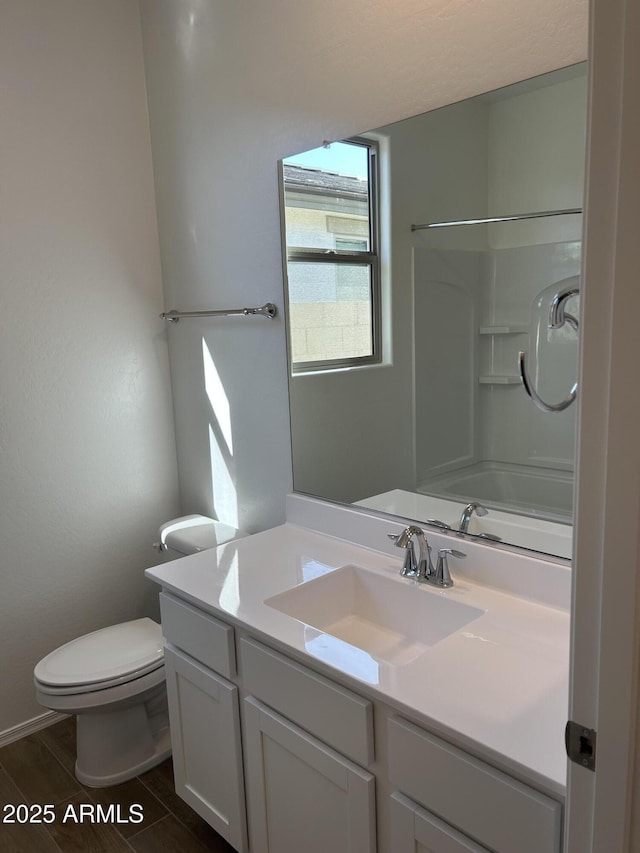 bathroom featuring vanity, toilet, and walk in shower