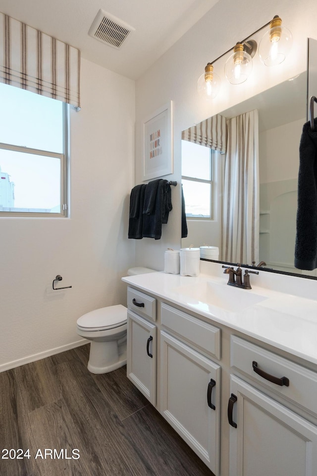 bathroom featuring hardwood / wood-style flooring, vanity, toilet, and a shower with shower curtain