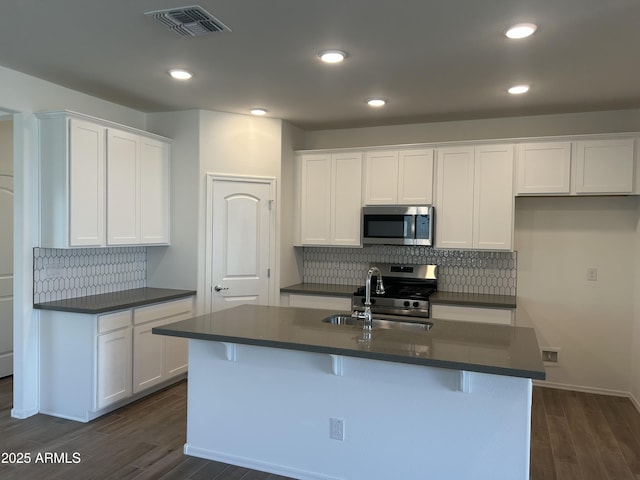 kitchen with white cabinets, an island with sink, and appliances with stainless steel finishes