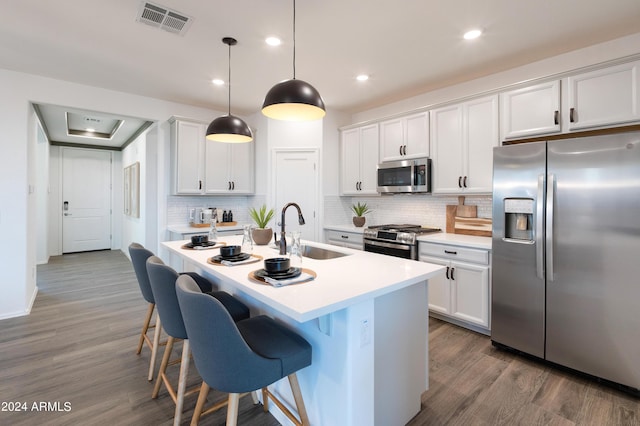 kitchen with white cabinets, appliances with stainless steel finishes, pendant lighting, and sink