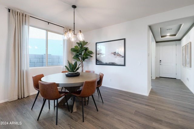 dining room with dark hardwood / wood-style flooring and a chandelier