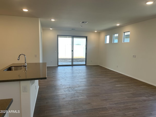 unfurnished living room with dark hardwood / wood-style floors and sink