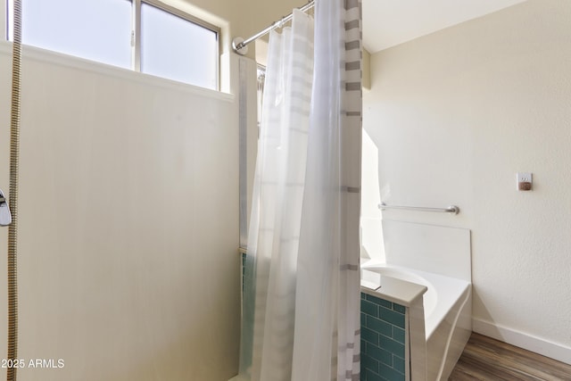 full bath with baseboards, a shower with shower curtain, wood finished floors, and a tub