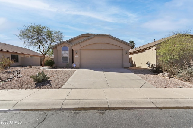 view of front of home with a garage, driveway, a tiled roof, and stucco siding