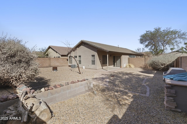 rear view of house featuring a fenced backyard, a patio, and stucco siding