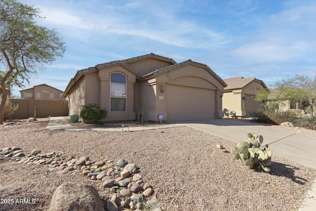 view of front facade featuring driveway, an attached garage, fence, and stucco siding