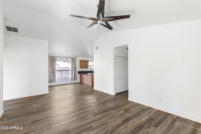 unfurnished living room with dark wood-style floors, visible vents, a ceiling fan, vaulted ceiling, and baseboards