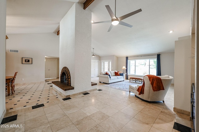 living room with high vaulted ceiling, light tile patterned flooring, a fireplace, and visible vents