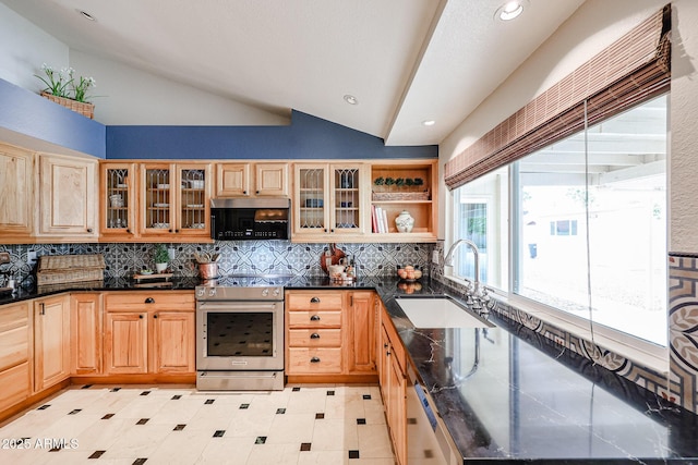 kitchen featuring lofted ceiling, stainless steel electric range oven, backsplash, and a sink