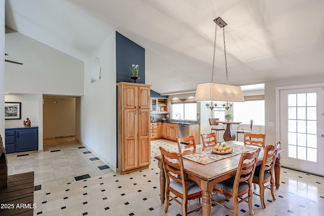 dining space with high vaulted ceiling