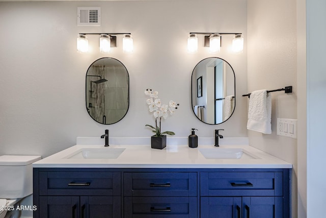 bathroom with visible vents, a sink, toilet, and double vanity