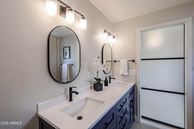 bathroom featuring double vanity, a sink, and speckled floor