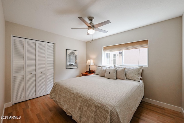 bedroom with a ceiling fan, a closet, baseboards, and wood finished floors