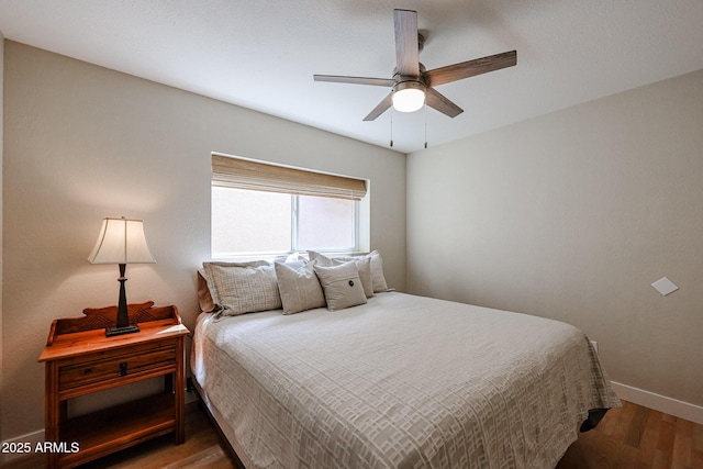 bedroom featuring a ceiling fan, baseboards, and wood finished floors