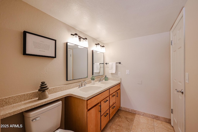 bathroom featuring double vanity, tile patterned flooring, a sink, and toilet