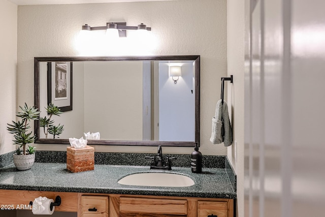 bathroom with a textured wall and vanity