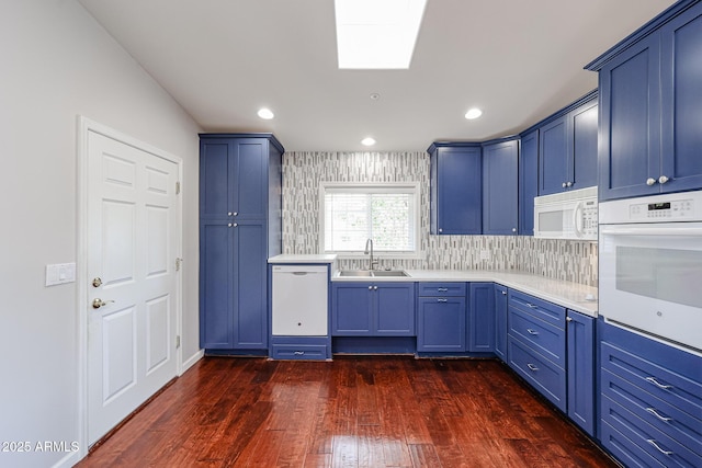 kitchen featuring blue cabinets, white appliances, dark wood-style flooring, a sink, and light countertops