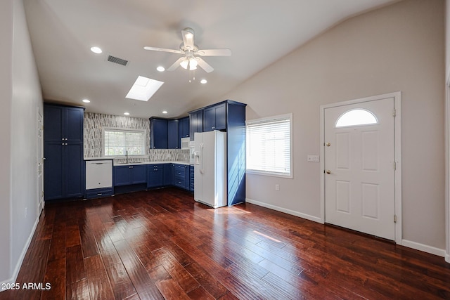 kitchen featuring visible vents, blue cabinetry, dark wood-style floors, and white appliances