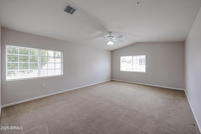 carpeted empty room with ceiling fan, baseboards, visible vents, and vaulted ceiling