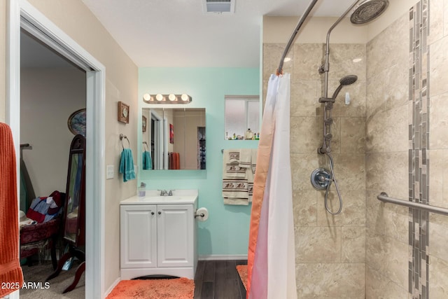 bathroom featuring vanity, a shower stall, wood finished floors, and visible vents