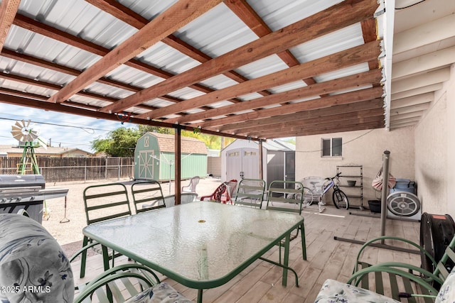 view of patio / terrace with a grill, a fenced backyard, a storage shed, an outbuilding, and outdoor dining space