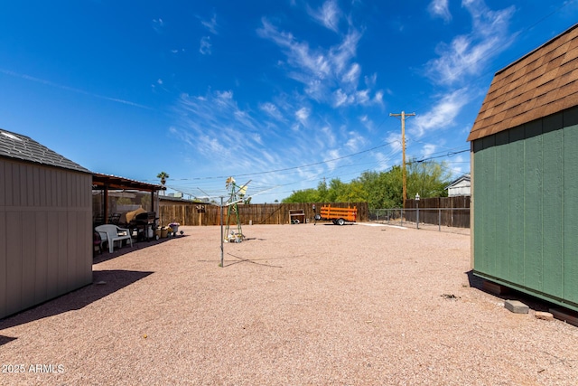 view of yard featuring an outbuilding, a fenced backyard, and a shed