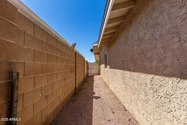 view of side of property featuring fence and stucco siding