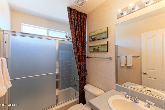 15371 W Piccadilly Rd, Goodyear, AZ 85395 - bathroom with toilet, vanity, visible vents, and bath / shower combo with glass door
