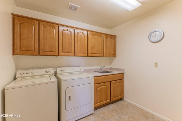 15371 W Piccadilly Rd, Goodyear, AZ 85395 - clothes washing area with a sink, cabinet space, washer and clothes dryer, visible vents, and baseboards