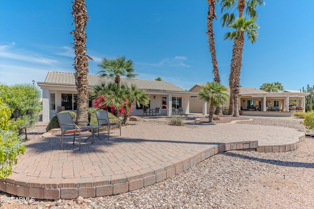 15371 W Piccadilly Rd, Goodyear, AZ 85395 - rear view of house featuring covered porch, a patio, a tile roof, and stucco siding