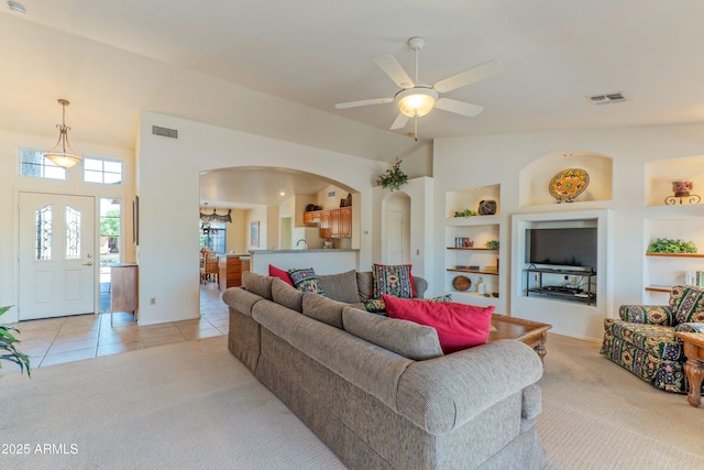15371 W Piccadilly Rd, Goodyear, AZ 85395 - living room featuring light carpet, arched walkways, and visible vents