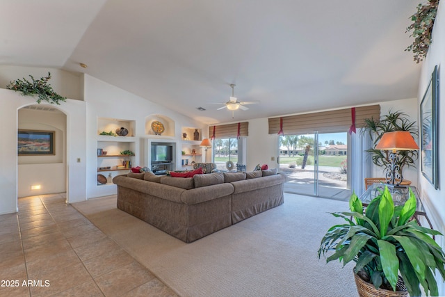 15371 W Piccadilly Rd, Goodyear, AZ 85395 - living area featuring lofted ceiling, light tile patterned flooring, a ceiling fan, and built in shelves